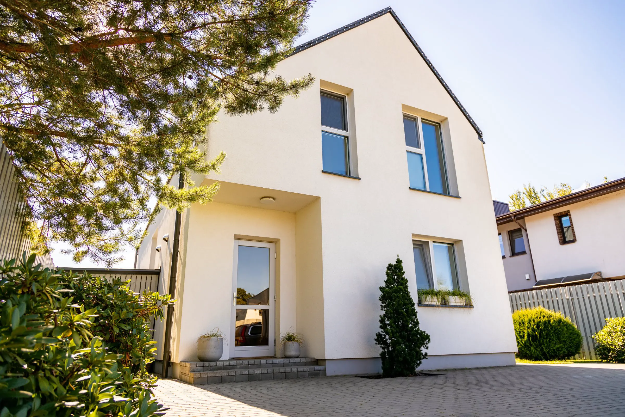 Helles Einfamilienhaus mit begrüntem Vorgarten.